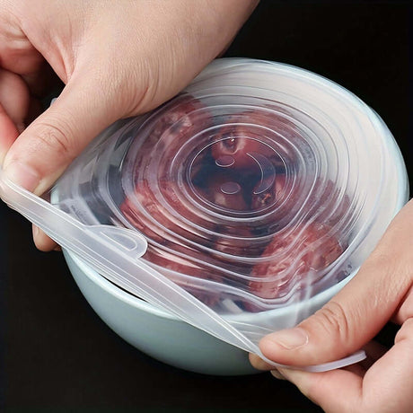 Hands placing a reusable silicone Flexilid on a bowl of grapes for food storage and preservation.