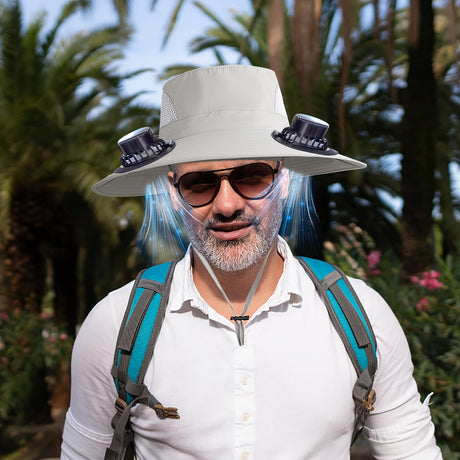 Man wearing a men's adjustable fan hat with USB-powered fans, hiking in a tropical setting.