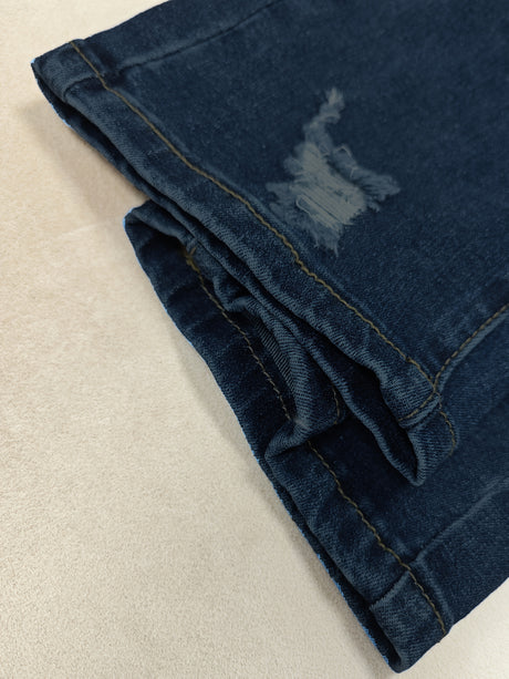 Close-up of the hem of new ripped skinny jeans showcasing the frayed detail and medium stretch fabric.