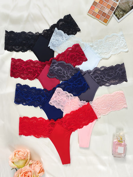 Flat lay of 12pcs women's low-waist thongs in various colors with lace details, surrounded by roses and perfume.