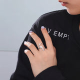 Woman wearing a stylish silver ring, showcasing a modern design on her hand.