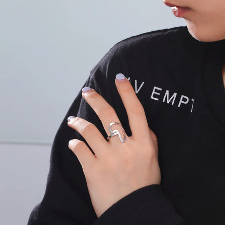 Woman wearing a stylish silver ring, showcasing a modern design on her hand.