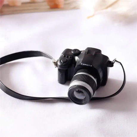 Miniature black camera for dollhouse, perfect for baby photography props or gifts.