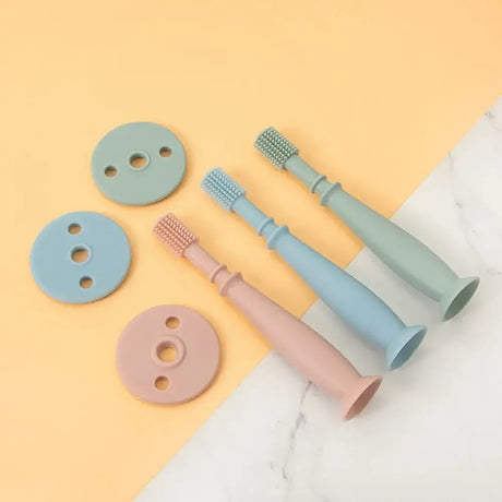 Colorful baby silicone training toothbrushes in pastel shades with round bases, ideal for infants and toddlers.