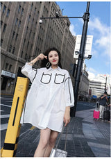 Woman wearing a stylish solid color shirt dress with pockets, posing on an urban street.