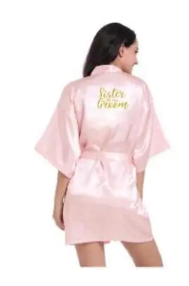 Elegant light pink satin bridesmaid robe with 'Sister of the Groom' text, perfect for wedding celebrations.