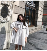 Solid color maternity shirt dress for summer beach parties with pockets and turn-down collar, styled in natural tones.