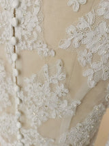 Close-up of crystal beaded lace appliqué design on a bridal bolero wedding jacket, showcasing intricate floral patterns.