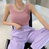 Model wearing a pink ribbed tank top paired with lavender joggers, showcasing a casual streetwear style.