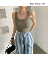 Model wearing a sleeveless olive green RetroRib™ tank top paired with light blue high-waisted jeans.
