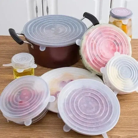 Set of adjustable silicone food covers in various sizes on bowls and pots, perfect for keeping food fresh and airtight.