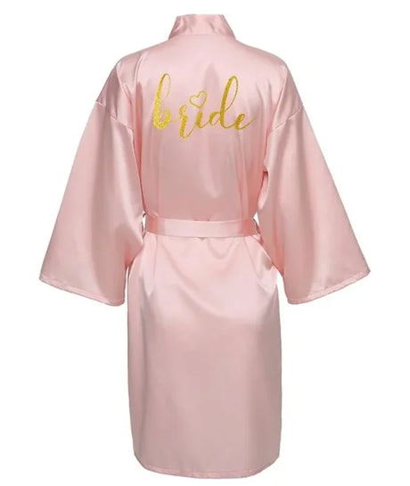 Pink satin kimono robe with gold 'bride' lettering on the back, perfect for wedding celebrations.