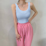 Light blue sleeveless ribbed tank top paired with pink sweatpants, showcasing a stylish streetwear look.