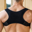 Rear view of an adjustable posture corrector back brace in black, designed for back support and alignment.