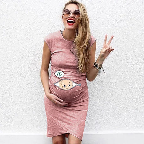 Smiling pregnant woman in casual loose maternity dress with cartoon baby design, embracing her pregnancy happily.
