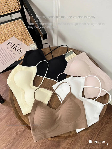 Collection of CrossForm™ padded backless tank tops in various colors on a wooden table, showcasing their summer style.