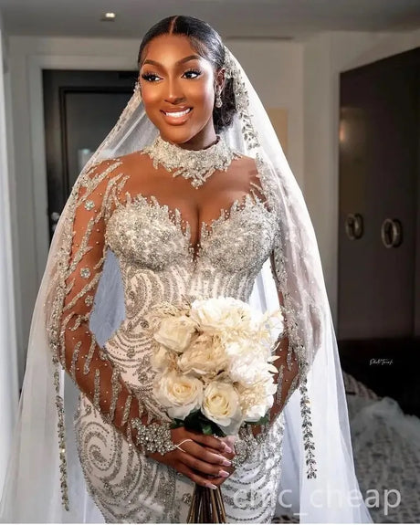 Luxury mermaid wedding dress with beaded sheer sleeves and a bouquet of flowers, designed for elegant brides.