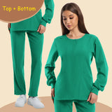 Women's long sleeve jogging style scrubs in green, featuring pockets and paired pants, ideal for medical professionals.