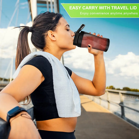 Woman drinking from a portable juicer with travel lid after workout, enjoying convenience anywhere.