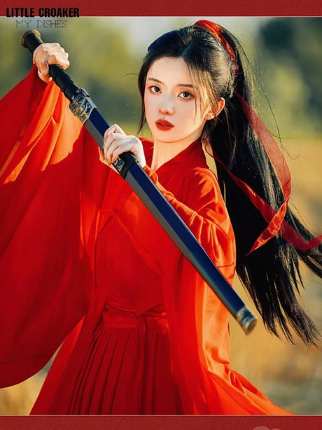 Model wearing a wine red Swordsman Hanfu Costume with a sword, representing Tang Dynasty style.