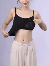 Woman adjusting Bralux™ built-in bra camisole with adjustable straps and soft inner layer, showcasing comfort and style.