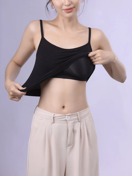 Woman adjusting Bralux™ built-in bra camisole with adjustable straps and soft inner layer, showcasing comfort and style.
