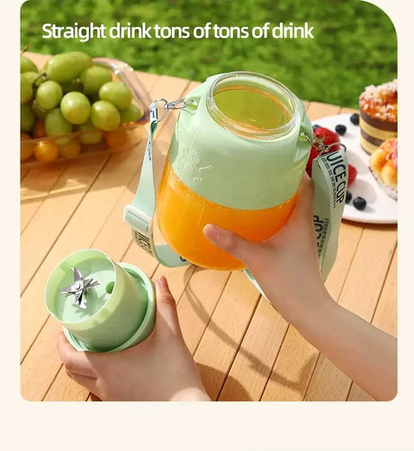 Hand holding a wireless portable juicing bucket with fresh juice, surrounded by fruits on a table.