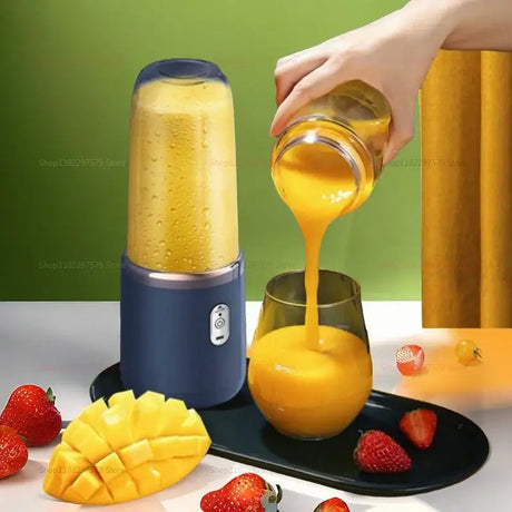 Portable 2 cup fruit juicer blender pouring smoothie into glass with strawberries and mango on plate.