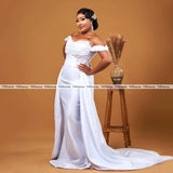 Elegant off-shoulder wedding dress with detachable train and pearl embellishments, perfect for brides.