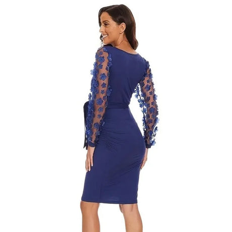 Back view of a woman in a vintage floral maternity gown with long sleeves in navy blue.