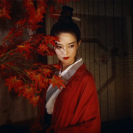 Swordsman Hanfu Costume model in wine red attire, showcasing Tang Dynasty elegance with autumn foliage backdrop.