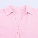 Close-up of a pink AsymLinen™ wide sleeve linen shirt with a turn-down collar and single breasted button closure.