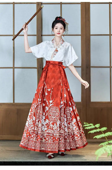 Woman in traditional oversized embroidered Hanfu blouse with intricate patterns and a flowing red skirt.
