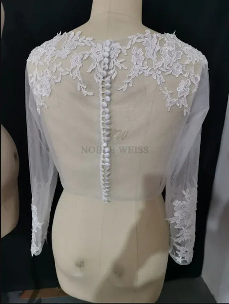 Lace bridal bolero jacket with long sleeves and appliques, showcasing intricate detailing and button closure at the back.