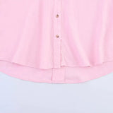 Light pink asymmetrical linen shirt with wide sleeves and button-down front.