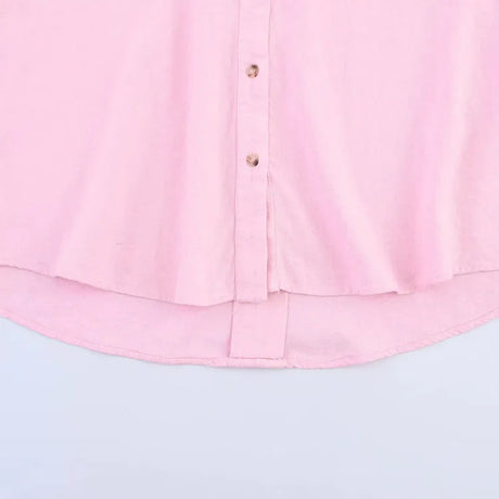 Light pink asymmetrical linen shirt with wide sleeves and button-down front.