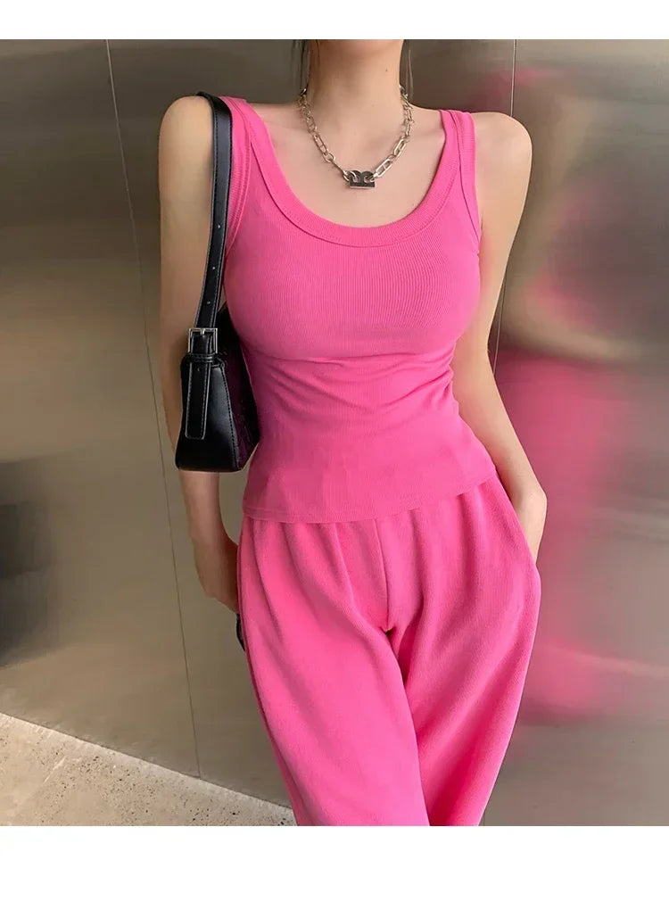 Model wearing RetroRib™ 90s vintage ribbed tank top in pink, styled with matching pants and a black handbag.