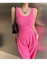 Model wearing RetroRib™ 90s vintage ribbed tank top in pink, styled with matching pants and a black handbag.