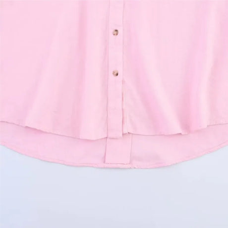 Close-up of a pink AsymLinen™ linen shirt featuring a button front and curved hemline.