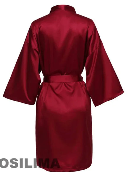 Back view of a luxurious burgundy satin robe with short sleeves and a belted waist.