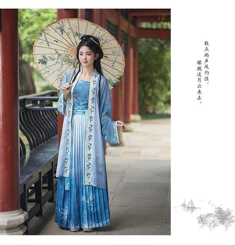 Elegant woman in a blue Hanfu cosplay dress holding a decorative parasol in a scenic outdoor setting.
