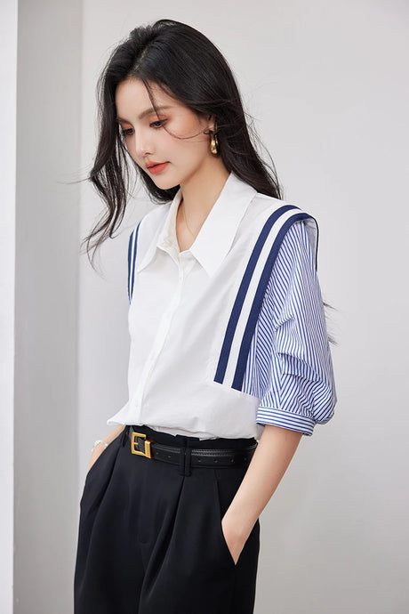 Woman wearing a colorblock chiffon shirt with navy blue and white stripes, styled for office casual look.