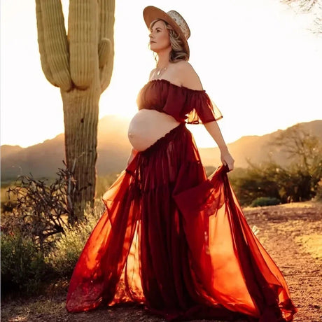 Boho two-piece maternity set, model in flowing red dress outdoors, golden hour photoshoot, desert backdrop.