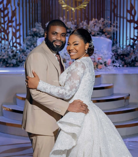 Happy couple celebrating their wedding, showcasing an elegant bridal gown and stylish suit in a beautiful venue.