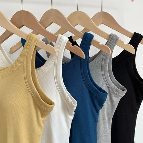 SlimCotz™ padded cotton spaghetti camis in various colors hanging on wooden hangers, showcasing summer slim fit and breathable design.