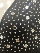 Close-up of shiny rhinestones and studs on black fabric, adding elegance to the maternity dress for summer events.