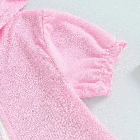 Close-up of toddler girls short sleeve pink hooded dress with ruched sleeve details.
