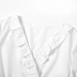 Close-up of a V-neck maternity dress with ruffled detailing in white cotton fabric.