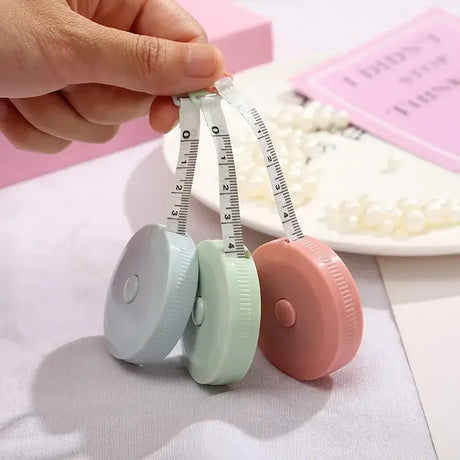 Colorful mini tape measures in hand, designed for easy height measurement and accurate readings for children.