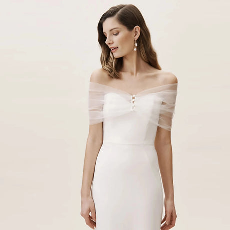 VG73 sheer wedding jacket worn over a white gown, featuring off-shoulder design with delicate buttons and flowing fabric.
